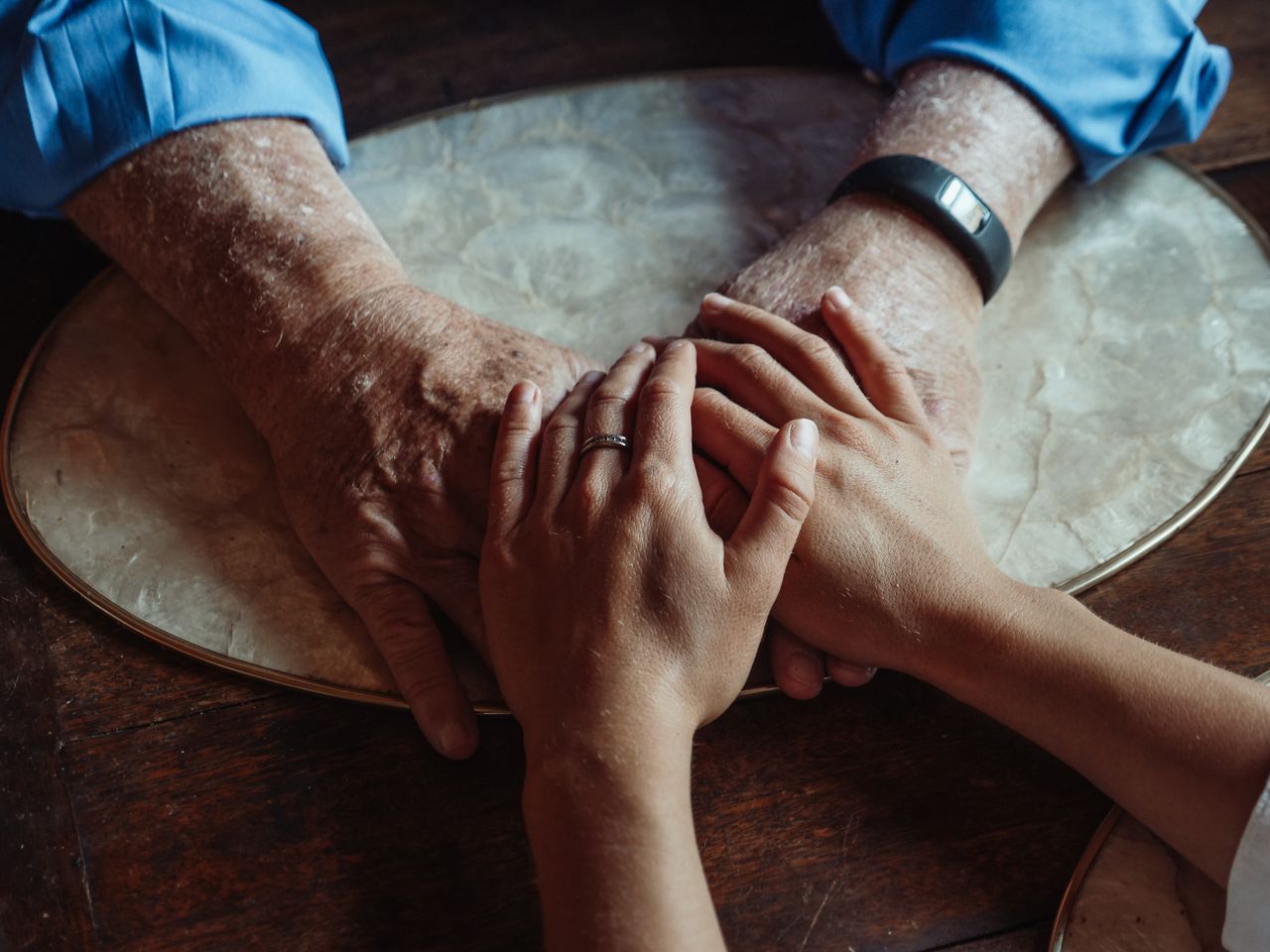 about-us Close-up of elderly and young hands joined, symbolizing compassion and support.